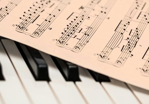 Black and white piano keys with a sheet of classical music creating a harmonious composition.